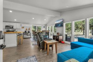 un soggiorno con un divano blu e una cucina di Peacock Pickleball Paradise a La Pine