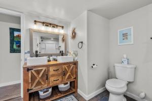 un bagno con lavandino, WC e specchio di Peacock Pickleball Paradise a La Pine Altre 34 foto