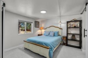 una camera da letto con un letto blu e una finestra di Peacock Pickleball Paradise a La Pine