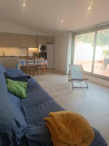 帕劳·萨巴尔德拉Sunny Relaxing Penthouse Costa Brava, Sea & Mountain Views, Huge Terrace, Fiber 1GB的一间带蓝色床的客厅和一间厨房