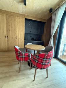 a table and chairs in a room with a kitchen at Apartmán Forest, Tatranská Štrba in Tatranska Strba +10 photos
