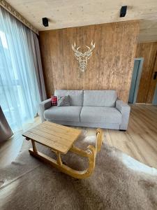 a living room with a couch and a coffee table at Apartmán Forest, Tatranská Štrba in Tatranska Strba