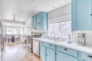 NetartsNetarts Bungalow的一间设有蓝色橱柜和一张桌子的大厨房