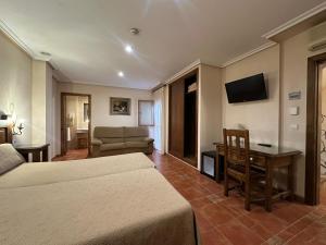 a hotel room with two beds and a couch at HOTEL Doña Isabel in Torrellano