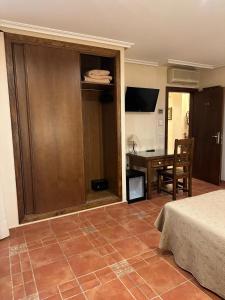 托雷利亚诺HOTEL Doña Isabel的一间卧室，配有书桌、一张床和一张桌子