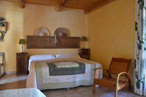 a bedroom with a bed and a chair at CASA-CORSA chambre d'hote in Cervione
