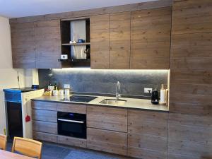a kitchen with wooden cabinets and a sink at Casa dei cugini in Oga