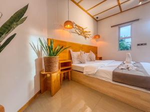 马提威力Eco Palm Maldives的一间卧室配有床和植物