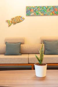 Una planta colocada sobre una mesa frente a dos camas. en Beachfront Katutubo Villa - where the world ends, en El Nido