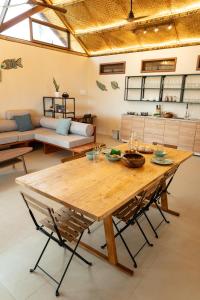 Un comedor con mesa y sillas de madera. en Beachfront Katutubo Villa - where the world ends, en El Nido