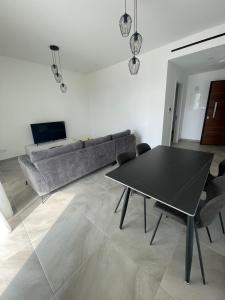 una sala de estar con una mesa y un sofá en Elite 1BD Flat with Pool in Harbor area, en Lárnaca