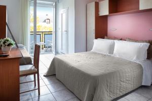 a bedroom with a large bed with a pink wall at Hotel Stacchini in Cesenatico +56 photos