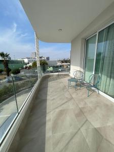 2 sillas sentadas en el balcón de un edificio en Elite 1BD Flat with Pool in Harbor area, en Lárnaca