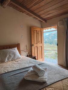 a bedroom with a bed with a large window at Mama Raywa in Chavín de Huantar