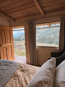 a bedroom with a bed and a large window at Mama Raywa in Chavín de Huantar +36 photos