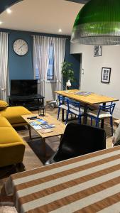 a room with tables and chairs and a clock on the wall at L’appart chic gapençais in Gap