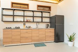 Una cocina con gabinetes de madera y refrigerador. en Beachfront Katutubo Villa - where the world ends, en El Nido 29 fotos más