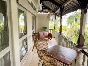 eine Veranda mit einem Holztisch und Stühlen in der Unterkunft Kresna By The Sea By Kresna Hospitality in Seminyak