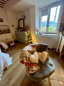 a living room with a chair and a christmas tree at Appartement cosy dans le centre historique de Vence in Vence