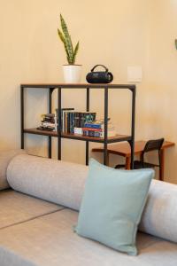 Un sofá con un estante con libros y una almohada. en Beachfront Katutubo Villa - where the world ends, en El Nido