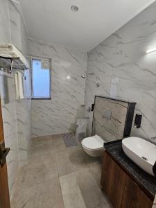 un bagno con un water bianco e un lavandino di Corbett Crown Resort a Ramnagar Altre 13 foto