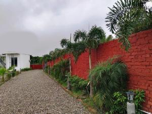 un muro di mattoni rossi con un sentiero accanto di Corbett Crown Resort a Ramnagar