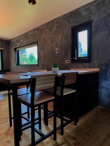 a dining room with two tables and chairs and two windows at Refugio Nauru in Puerto Dunn