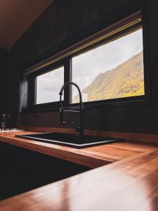 a sink in a kitchen with a window at Refugio Nauru in Puerto Dunn +2 photos
