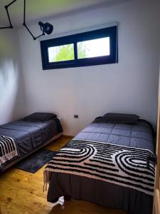 a bedroom with two beds and a window at Refugio Nauru in Puerto Dunn