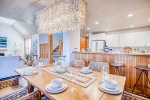 a dining room with a table with chairs and a chandelier at Sunshine and Sweaters in Pacific City