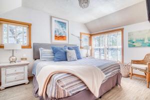 a bedroom with a bed and two windows at Sunshine and Sweaters in Pacific City