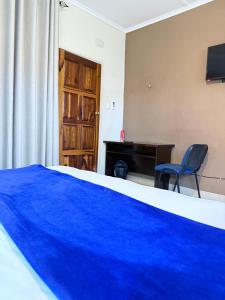 a bedroom with a blue blanket on a bed at Villa Thabiso in Bulawayo
