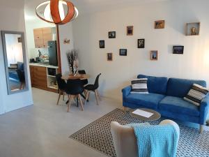 a living room with a blue couch and a table at La Cabine du Man, meublé de tourisme classé 2 étoiles in Roscoff