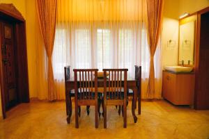 a dining room table with two chairs and a window at Sandra Suite Ranga illam in Tiruvannāmalai