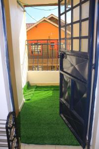 eine offene Tür zu einem Balkon mit grünem Gras in der Unterkunft Anifar cozy home in Kahawa