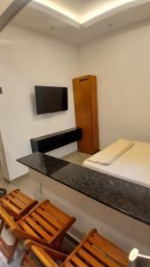 Camera con letto e scrivania con sedie. di Loft Centro a Aparecida