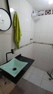 un bagno con un lavandino verde e una doccia di Loft Centro a Aparecida Altre 7 foto