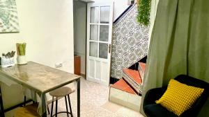 Zimmer mit einem Tisch, Stühlen und einer Tür in der Unterkunft casa rústica Ronda in Ronda