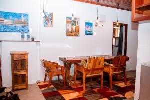 Un comedor con mesa y sillas de madera. en Kay's place Trainhouse apartments, en Zanzíbar 165 fotos más