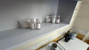 A Predore il tuo nido a due passi dal lago في بريدور: حمام بثلاث زجاجات على رف فوق المرحاض