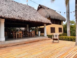 una silla en una terraza de madera frente a un edificio en Hostal nido tortuga, en San Antero