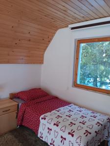 een kleine slaapkamer met een bed en een raam bij Vikendica in Vlasic