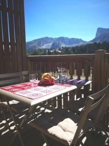 een tafel met glazen en een bord met eten op een terras bij Appartement Super-Dévoluy in Le Dévoluy
