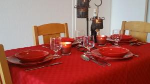 een tafel met rode borden en glazen op een rood tafelkleed bij Appartement Super-Dévoluy in Le Dévoluy +10 foto's