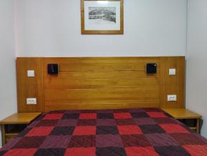 een slaapkamer met een bed met een geruite deken bij Appartement Super-Dévoluy in Le Dévoluy