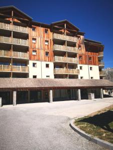 een groot appartementencomplex met een parkeerplaats ervoor bij Appartement Super-Dévoluy in Le Dévoluy