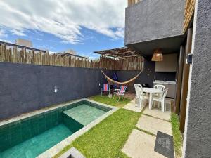 a backyard with a swimming pool and a table and chairs at MHV Milagres - Studio Guadalupe 05, quarto e sala privativo a poucos metros da Praia do Marceneiro in Passo de Camarajibe