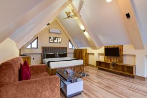 Camera con letto, divano e TV. di Hotel O AAHELI RESORT a Calcutta