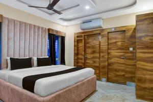 una camera con un grande letto e un armadio in legno di Hotel O AAHELI RESORT a Calcutta