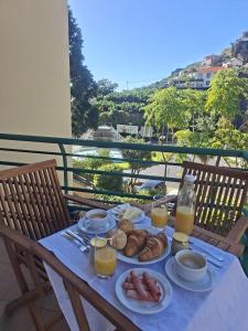 a table with plates of food and glasses of orange juice at Paradise Valley Ponta do Sol in Ponta do Sol
